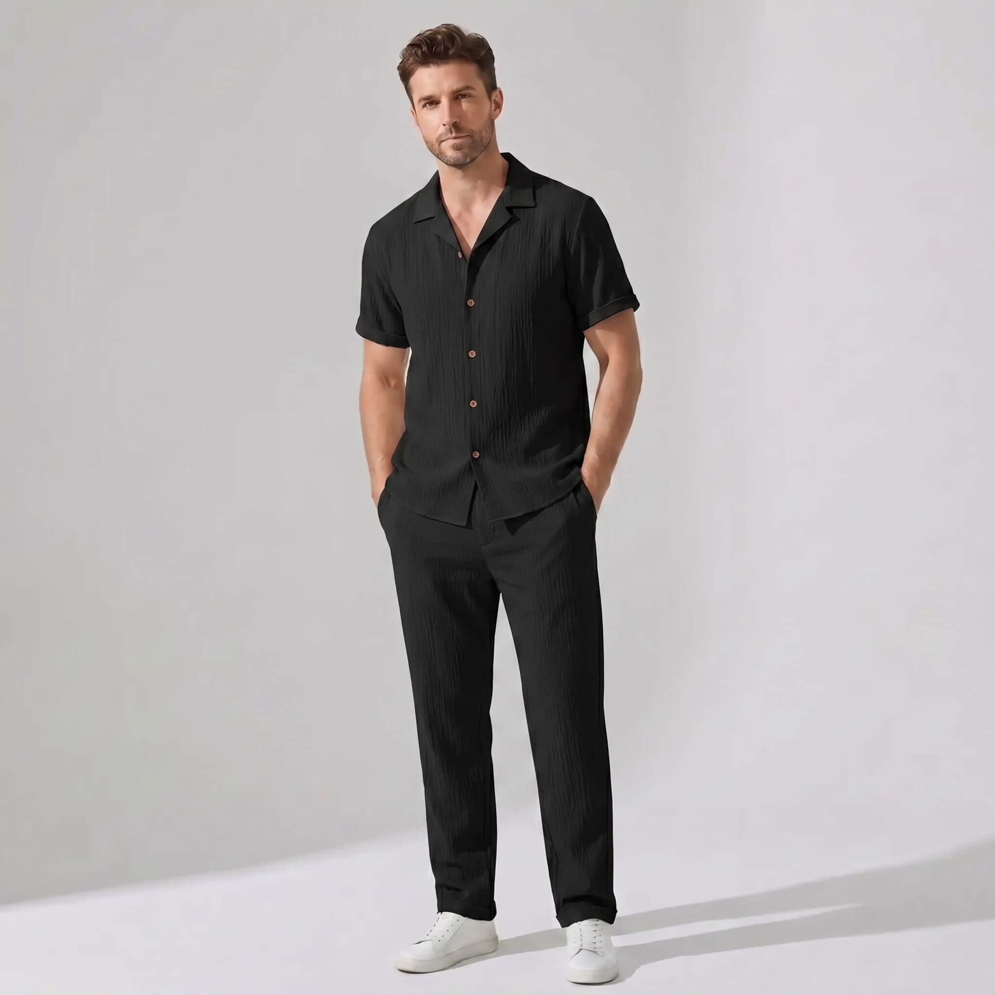 Man wearing a beige crinkled textured button up shirt and straight leg pants front view