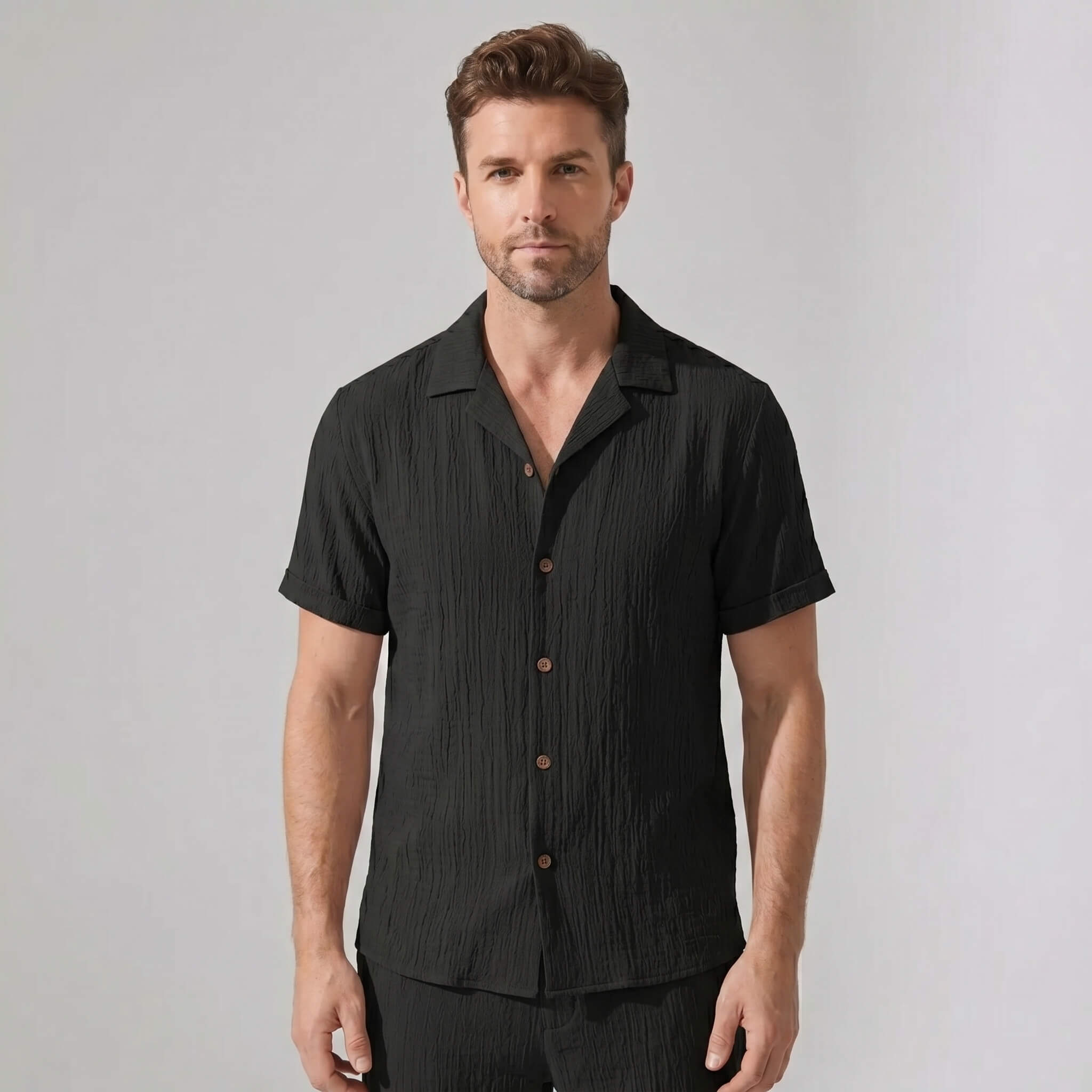 Three quarter view of man in beige crinkled textured shirt and straight leg pants