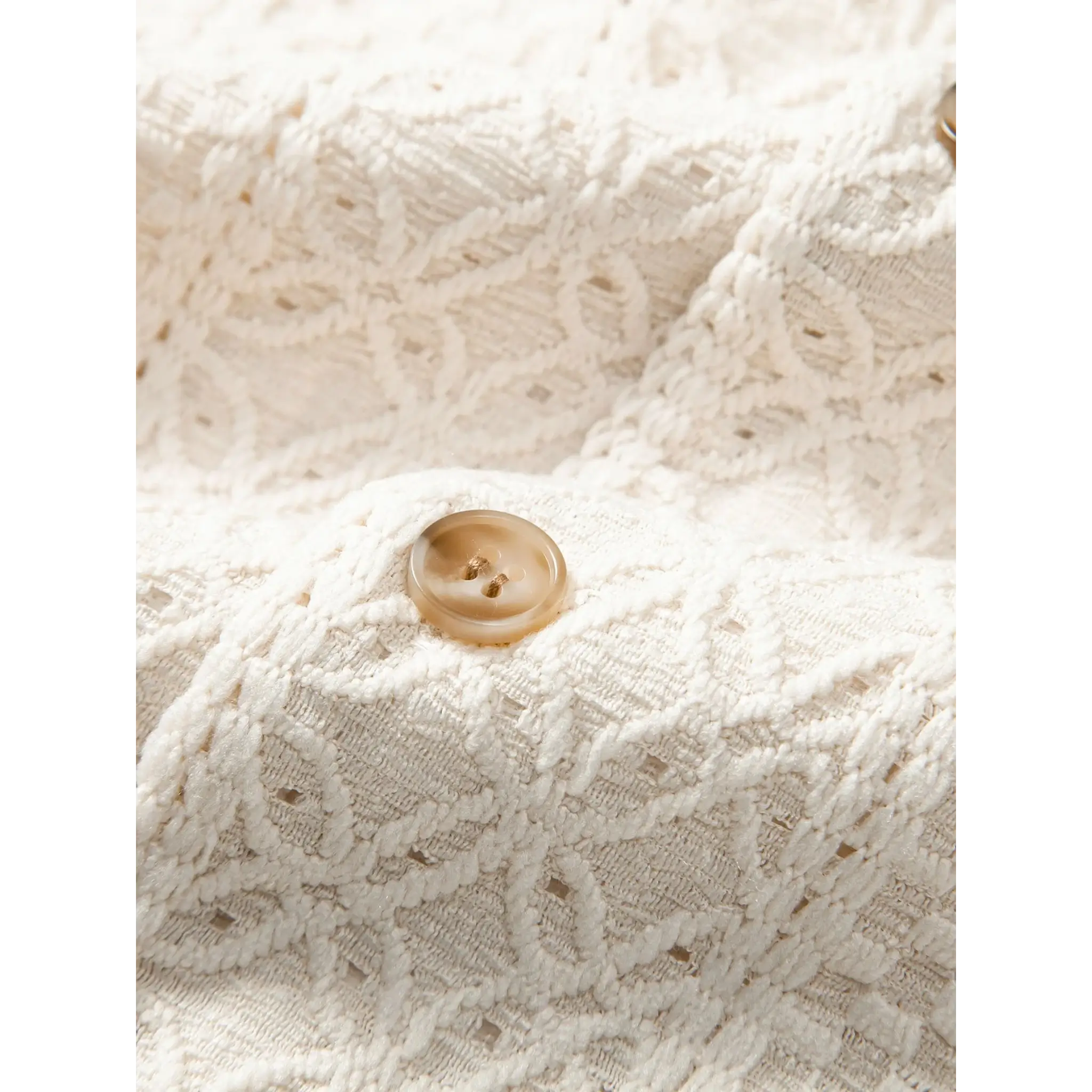 Close-up of beige floral checkerboard jacquard Cuban shirt open collar detail and chest area