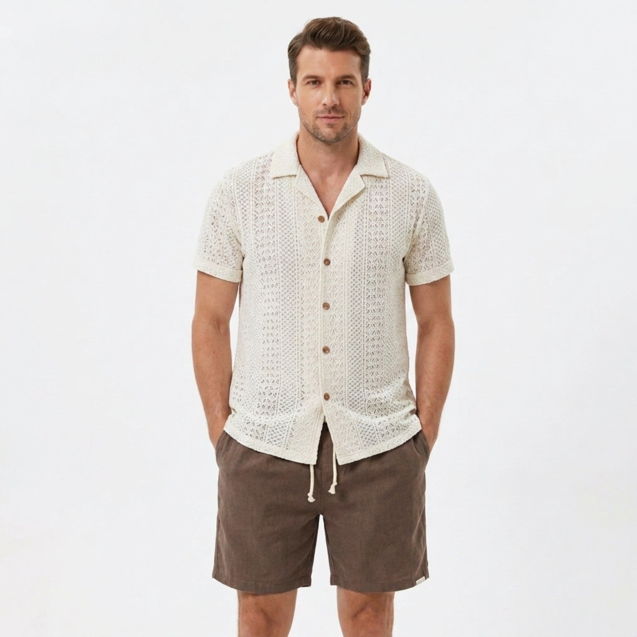 Back view of man wearing beige floral checkerboard jacquard Cuban shirt and linen drawstring shorts