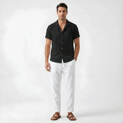 Man in beige floral checkerboard jacquard Cuban shirt and linen pants in outdoor summer lifestyle