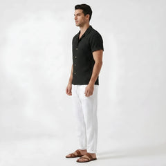 Man wearing beige floral checkerboard jacquard Cuban shirt and linen pants in sunny outdoor environment