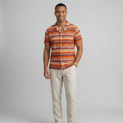 Man wearing a beige geometric Cuban shirt and straight leg linen pants front view on plain background