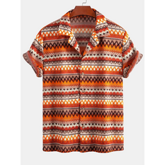 Man in beige geometric Cuban shirt and linen pants walking in sunny outdoor summer scene