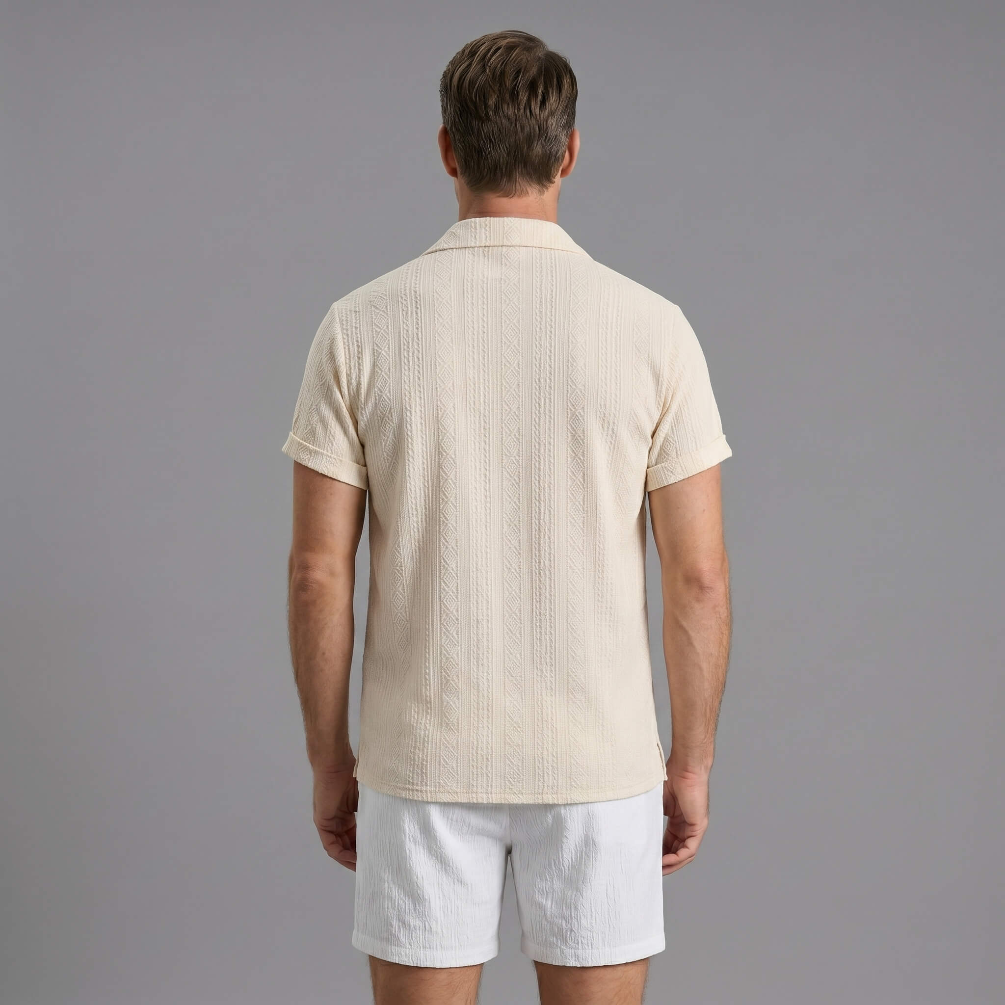 Back view of man wearing beige geometric jacquard shirt and crinkle textured shorts