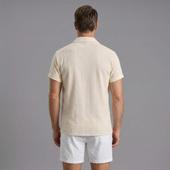 Back view of man wearing beige geometric jacquard shirt and crinkle textured shorts
