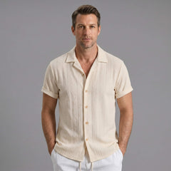 Three quarter view of man in beige geometric jacquard shirt and crinkle shorts