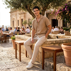Man in beige geometric jacquard button up shirt and linen pants in outdoor lifestyle setting
