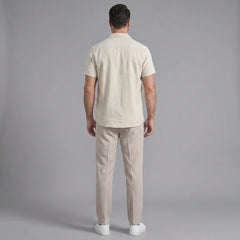 Back view of man wearing beige linen Cuban collar shirt and slim fit tapered trousers