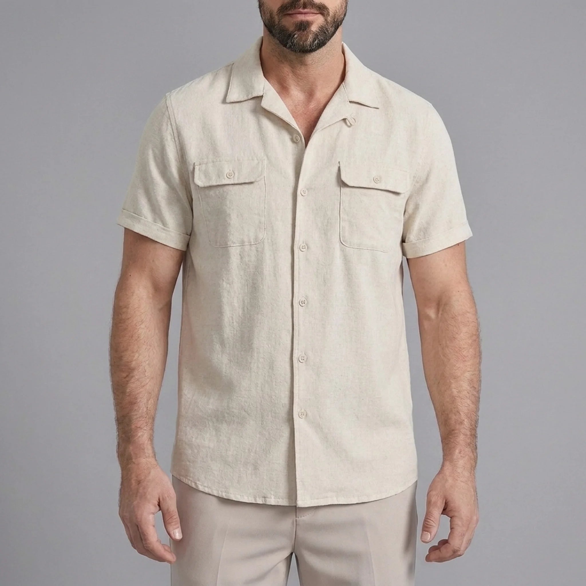 Three quarter view of man in beige linen Cuban collar shirt and slim fit tapered trousers