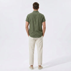 Back view of man wearing beige linen rayon blend utility shirt and straight leg linen pants