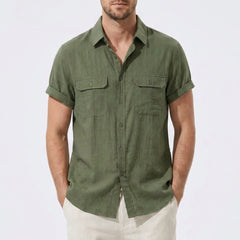 Three quarter view of man in beige linen rayon blend utility shirt and linen pants on plain background