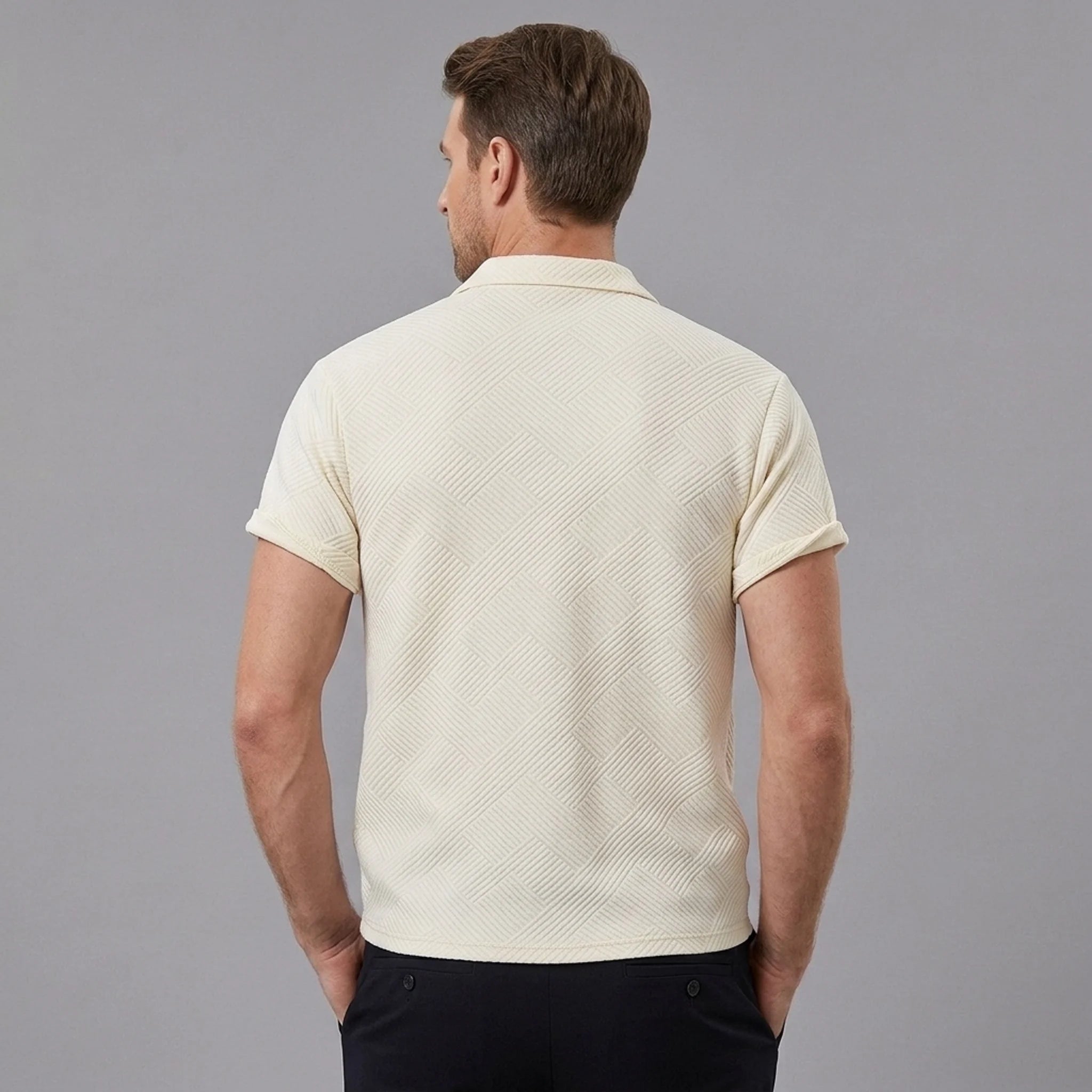 Side view of man in beige stripe jacquard zip-up polo shirt on plain background