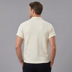 Side view of man in beige stripe jacquard zip-up polo shirt on plain background