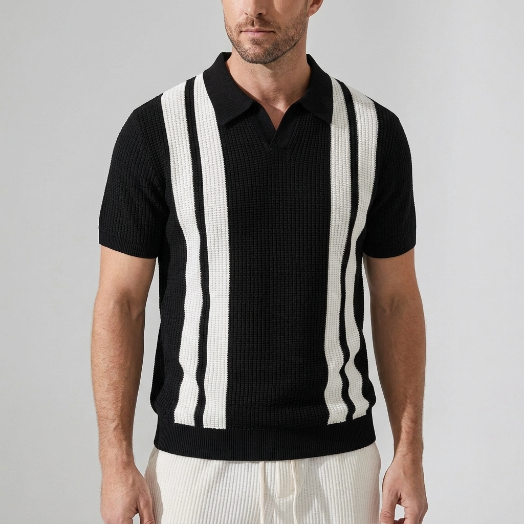 Three quarter view of man in black striped knit polo and beige pants