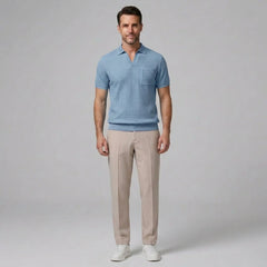 Man in beige waffle johnny collar polo and tapered pants walking in sunny outdoor summer scene