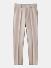 Full length view of man wearing beige waffle polo and tapered pants on plain background
