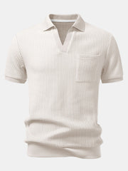 Man wearing beige waffle johnny collar polo shirt and slim fit tapered pants in outdoor lifestyle setting