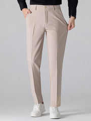 Man wearing beige waffle johnny collar polo and tapered pants relaxing in outdoor setting