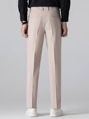Man wearing beige waffle polo and tapered pants three quarter view on plain background