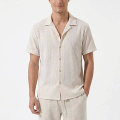 Man in beige geometric jacquard shirt and linen pants front view