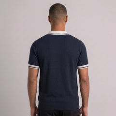 Man wearing black color block knit polo shirt in outdoor lifestyle setting