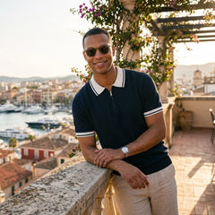 Man in black color block knit polo shirt in sunny outdoor scene