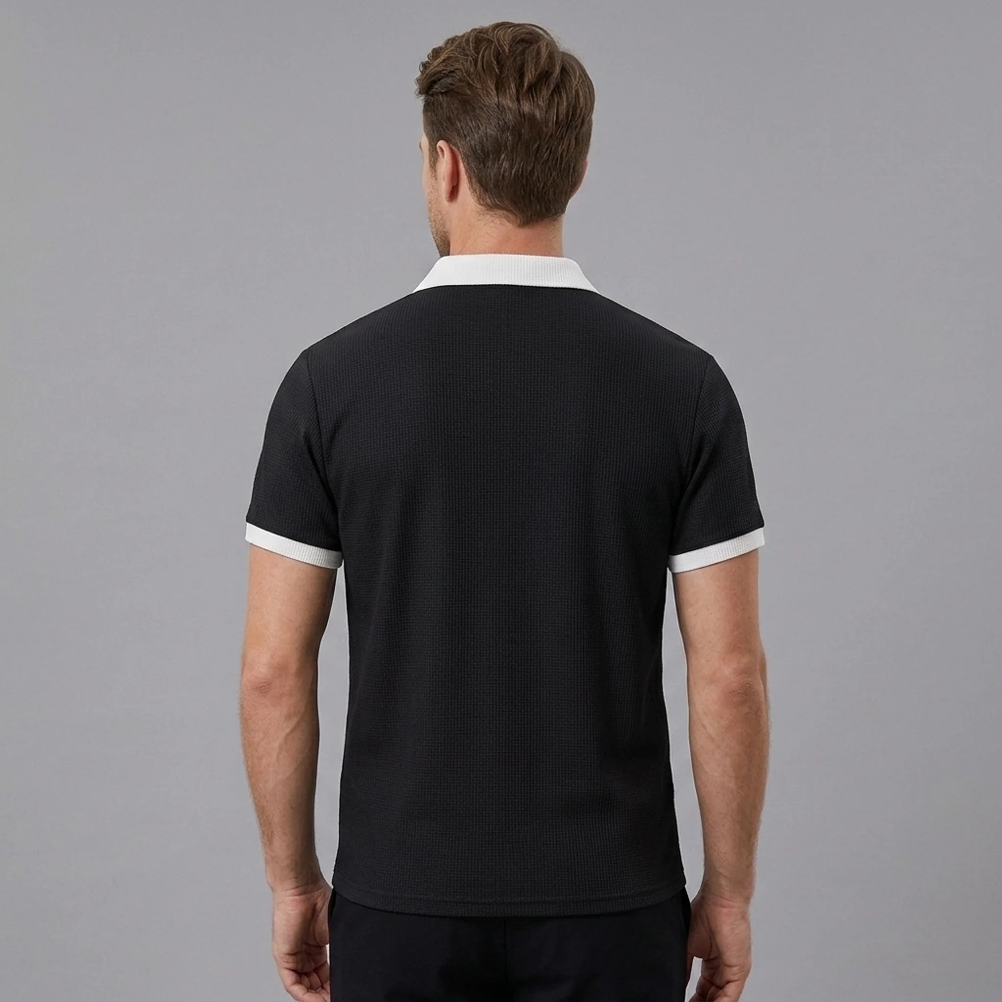 Man in black color block waffle polo shirt in sunny outdoor scene