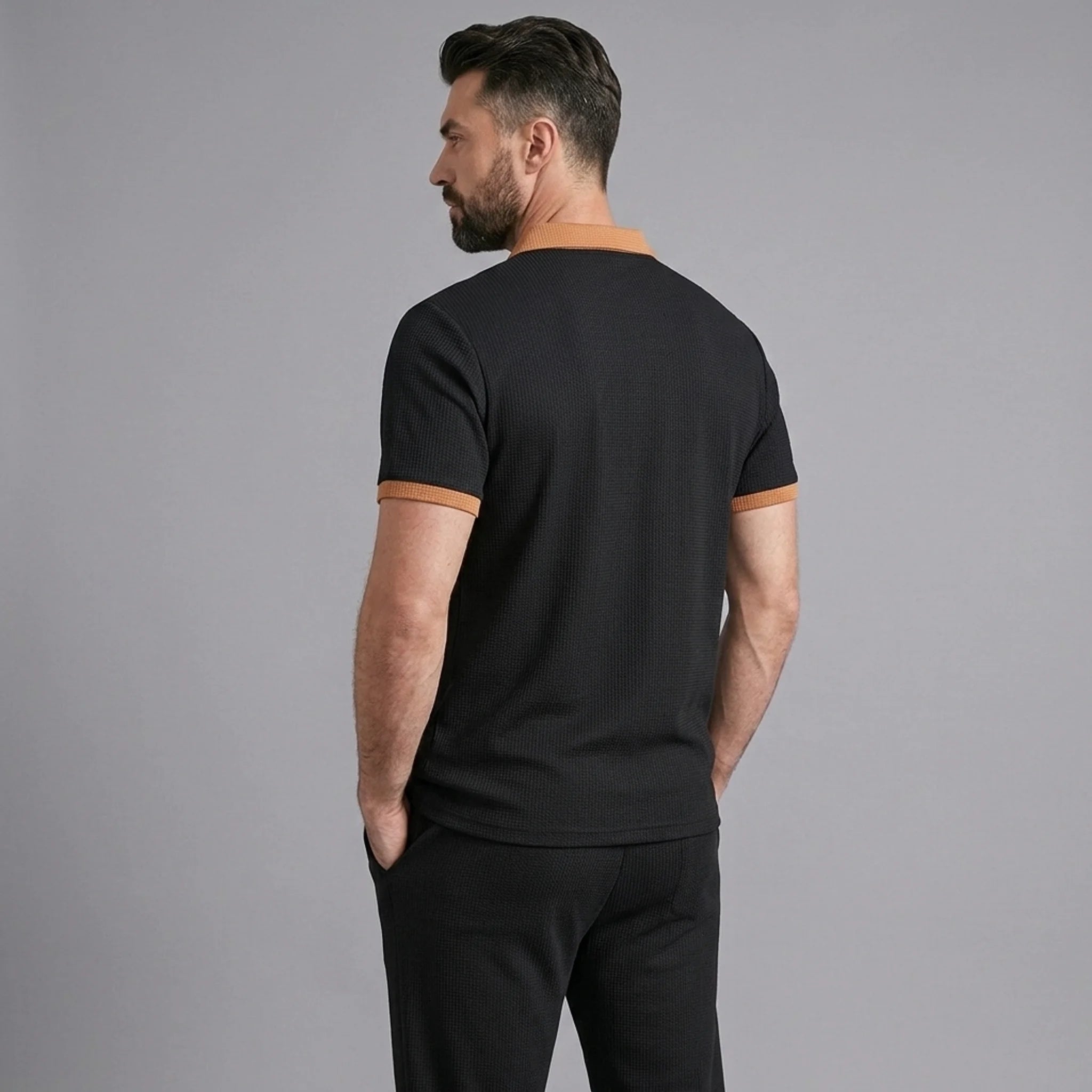 Back view of man wearing black color block waffle polo and straight leg pants