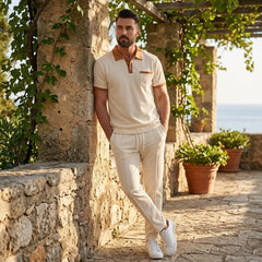 Man wearing a black color block waffle polo shirt and straight leg pants front view on plain background