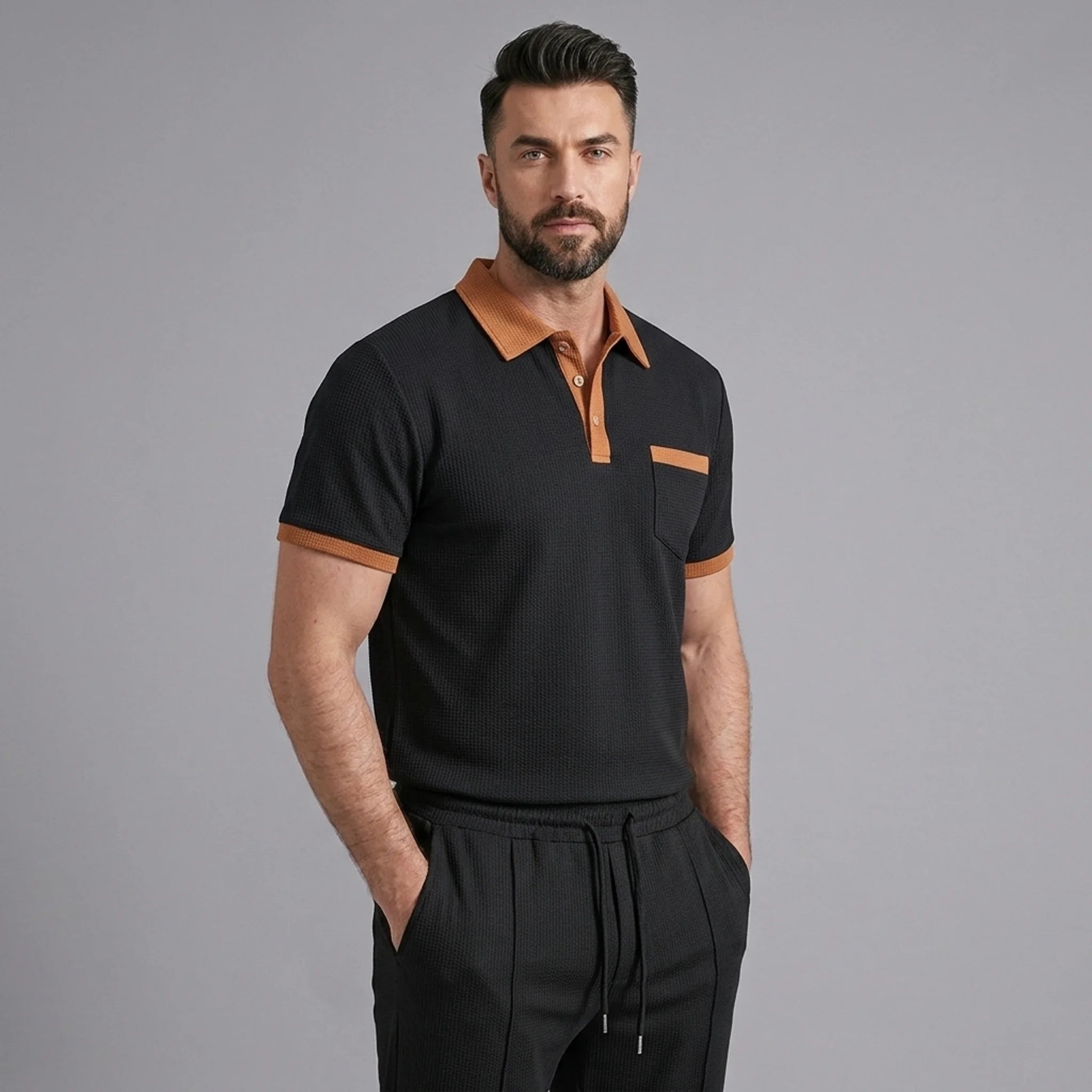 Three quarter view of man in black color block waffle polo and straight leg pants