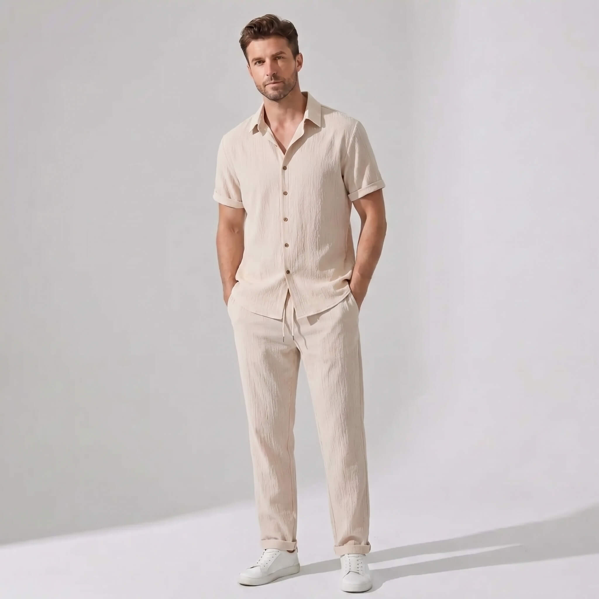 Man wearing a black crinkled textured button up shirt and straight leg pants front view