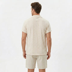 Man wearing black floral checkerboard jacquard Cuban shirt and linen cotton drawstring shorts front view
