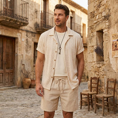 Man in black floral checkerboard jacquard Cuban shirt and linen drawstring shorts in outdoor summer scene