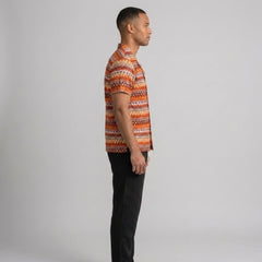 Back view of man wearing black geometric Cuban shirt and straight leg linen pants