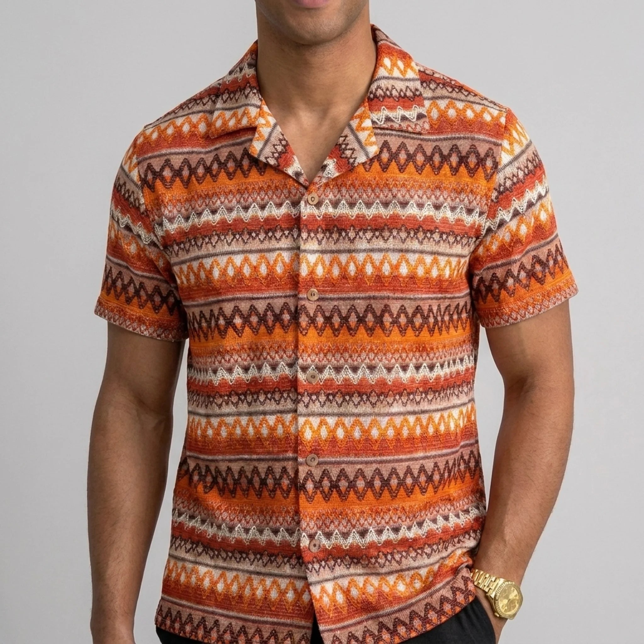 Man wearing black geometric Cuban shirt and straight leg linen pants in outdoor lifestyle setting