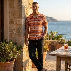 Man in black geometric Cuban shirt and linen pants in sunny outdoor summer scene