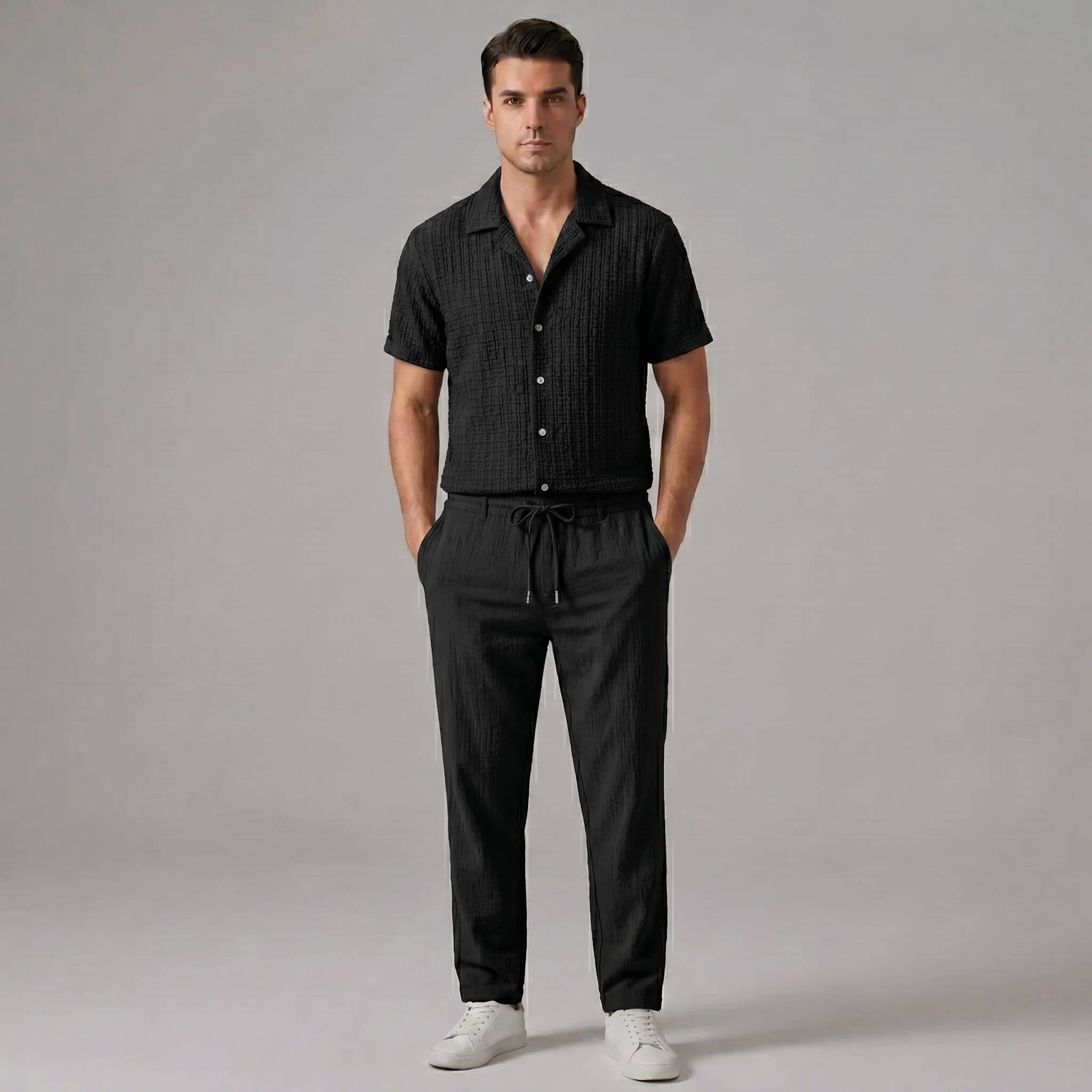 Man wearing black jacquard Cuban collar shirt and crinkle textured straight leg pants front view