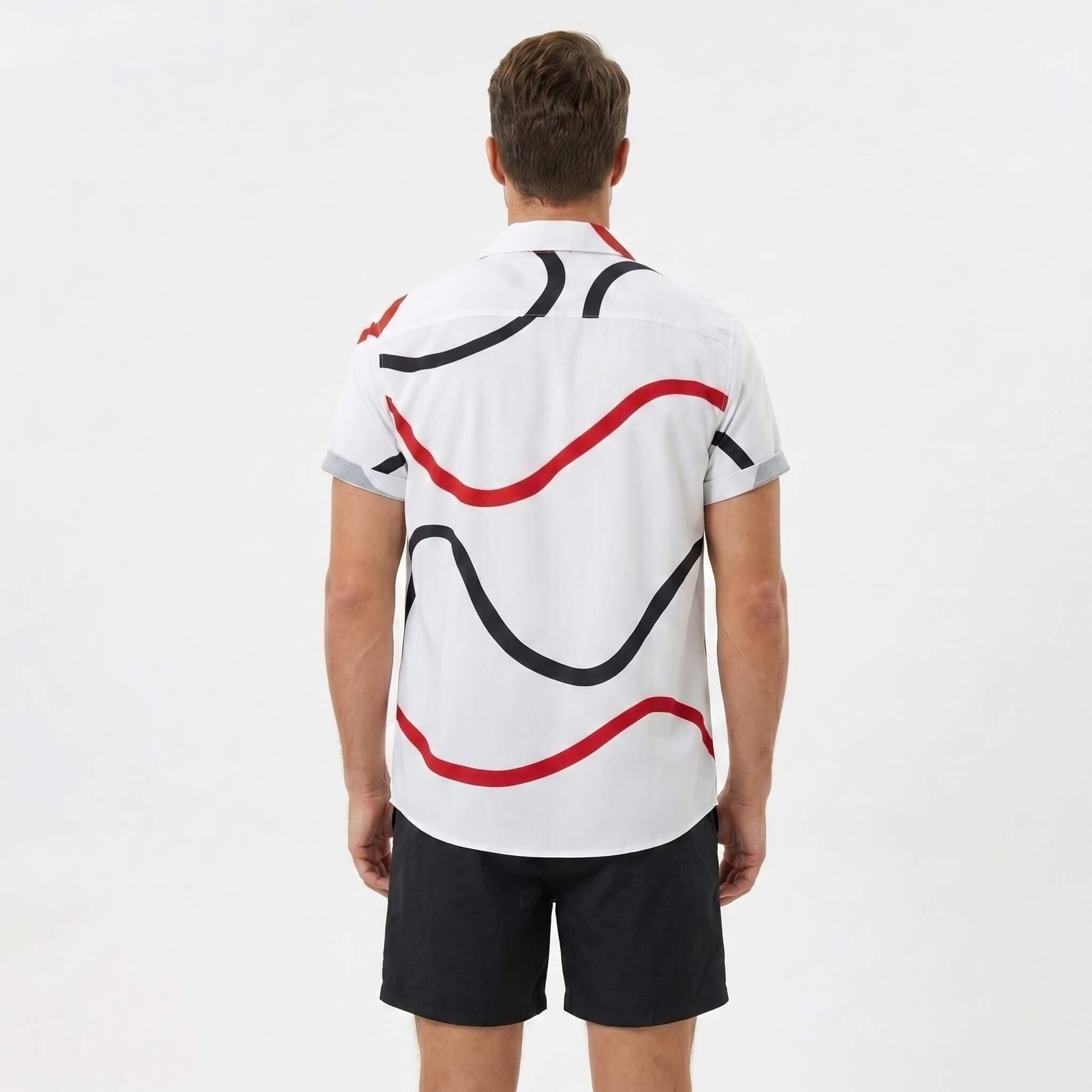 Back view of man wearing black line print button up shirt and swim shorts