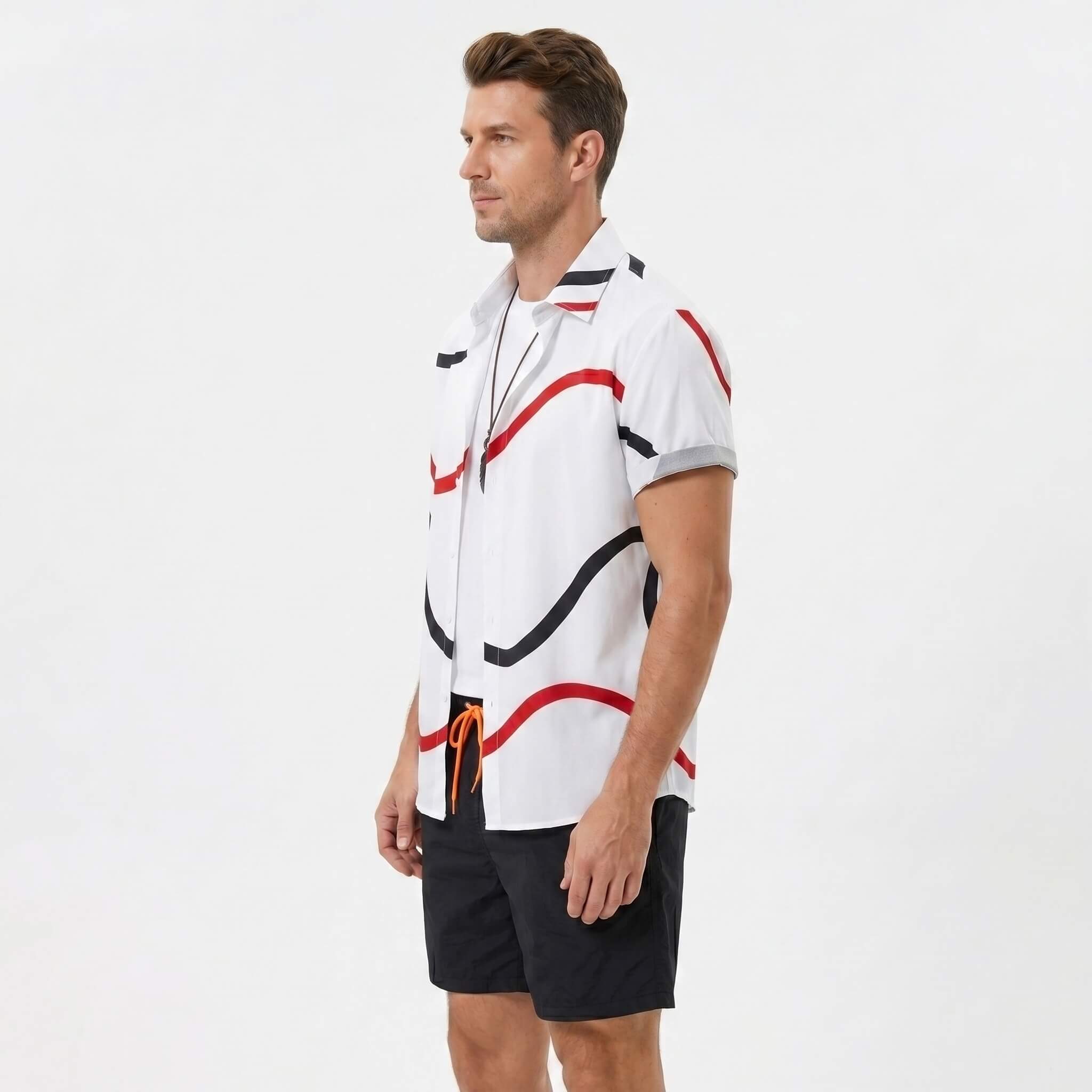 Side view of man in black line print button up shirt and swim shorts on plain background