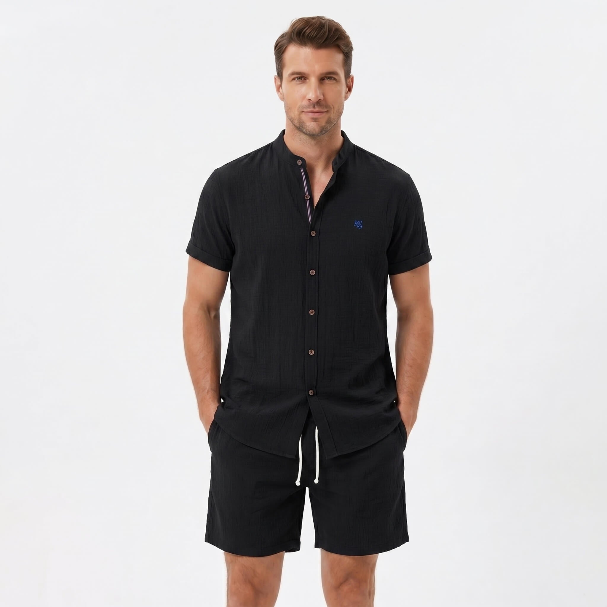 Man wearing a black linen look stand collar shirt and crinkle textured drawstring shorts front view