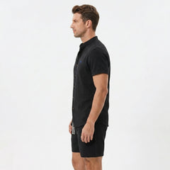 Side view of man in black linen look stand collar shirt and crinkle textured drawstring shorts