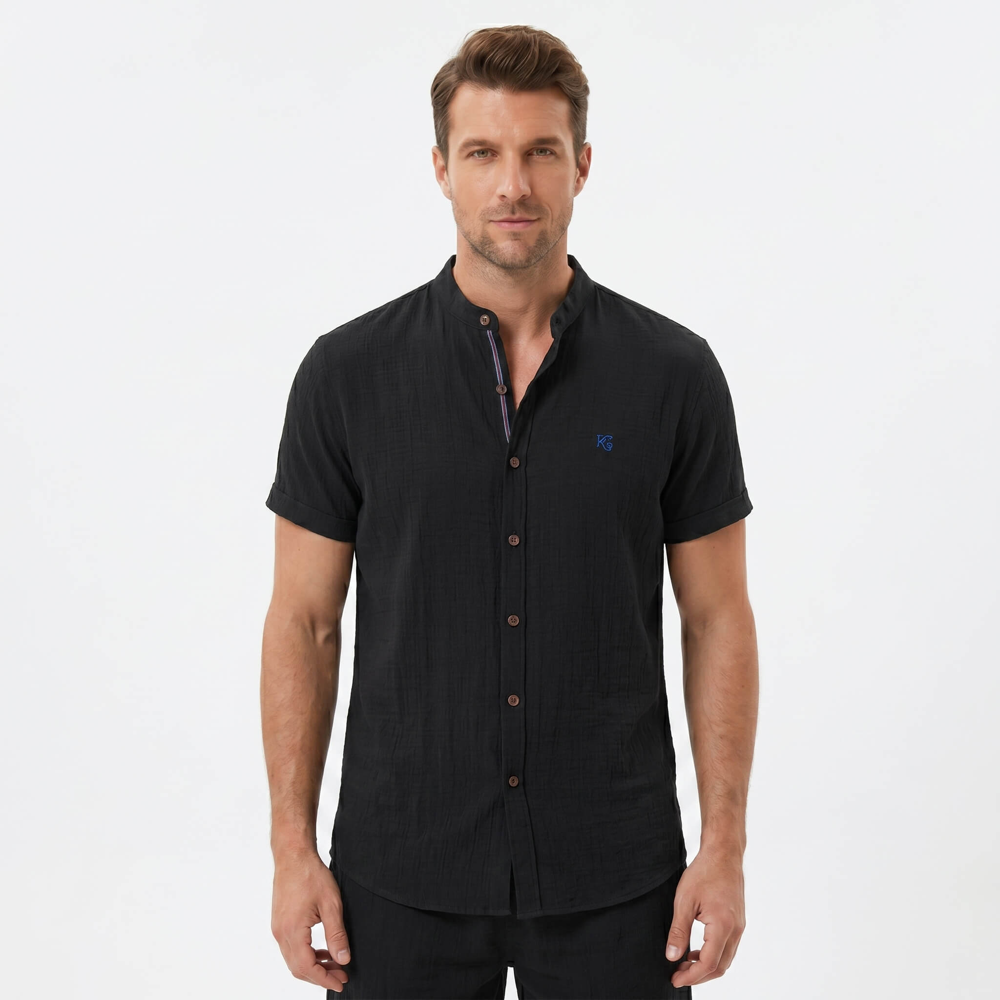 Three quarter view of man in black linen look stand collar shirt and crinkle drawstring shorts