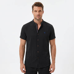 Three quarter view of man in black linen look stand collar shirt and crinkle drawstring shorts
