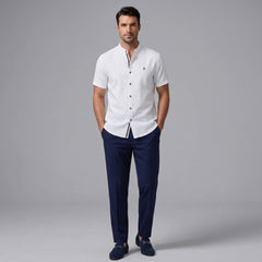 Man wearing a black linen look stand collar shirt and slim fit tapered trousers front view on plain background