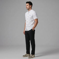 Full length view of man in black linen look stand collar shirt and slim tapered trousers on plain background