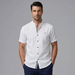 Man wearing black linen look stand collar shirt and slim tapered trousers in outdoor lifestyle setting