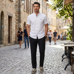 Man in black linen look stand collar shirt and slim tapered trousers in outdoor lifestyle scene