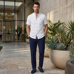 Man in black linen look stand collar shirt and slim tapered trousers in sunny outdoor scene