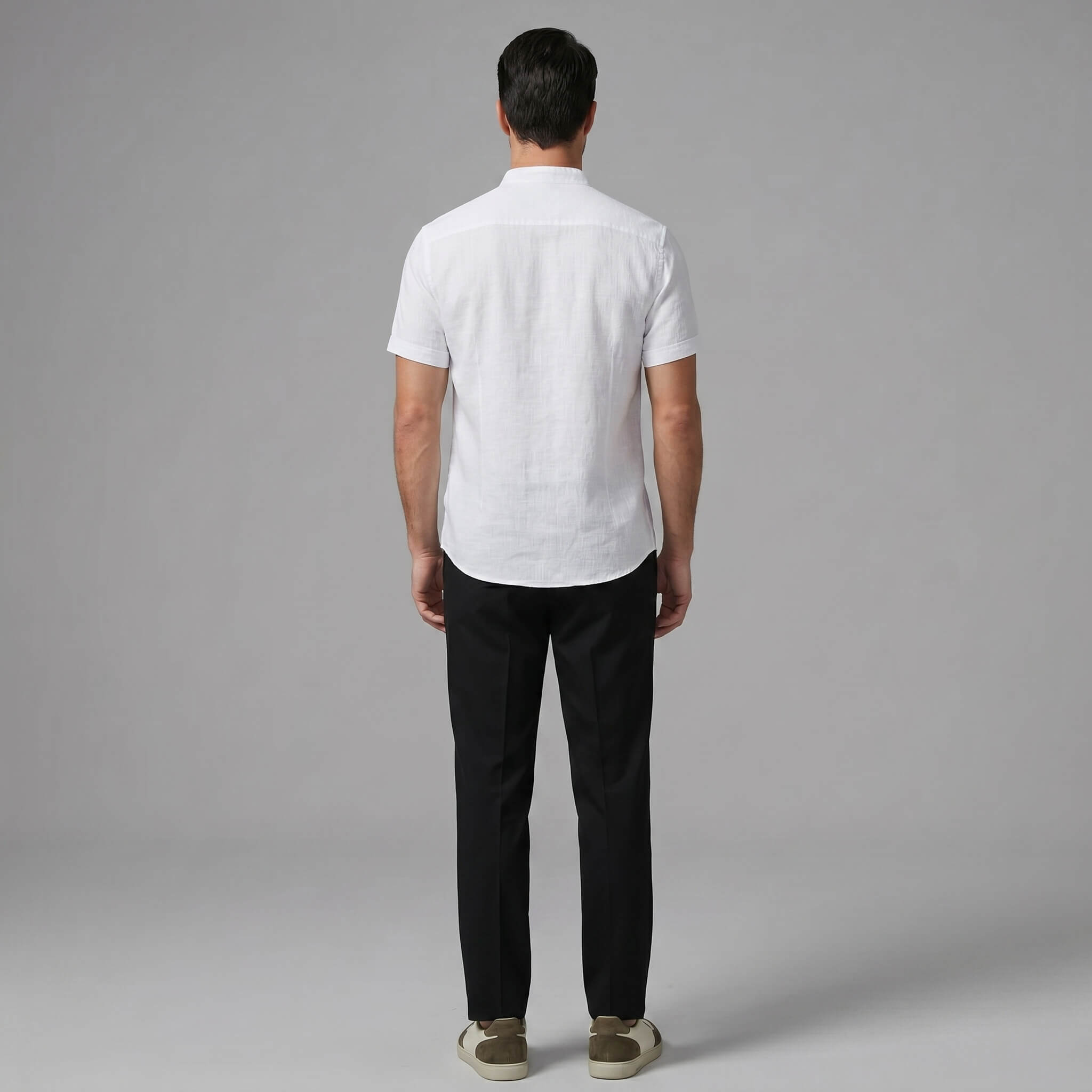 Man wearing black linen look stand collar shirt and tapered trousers in outdoor summer setting